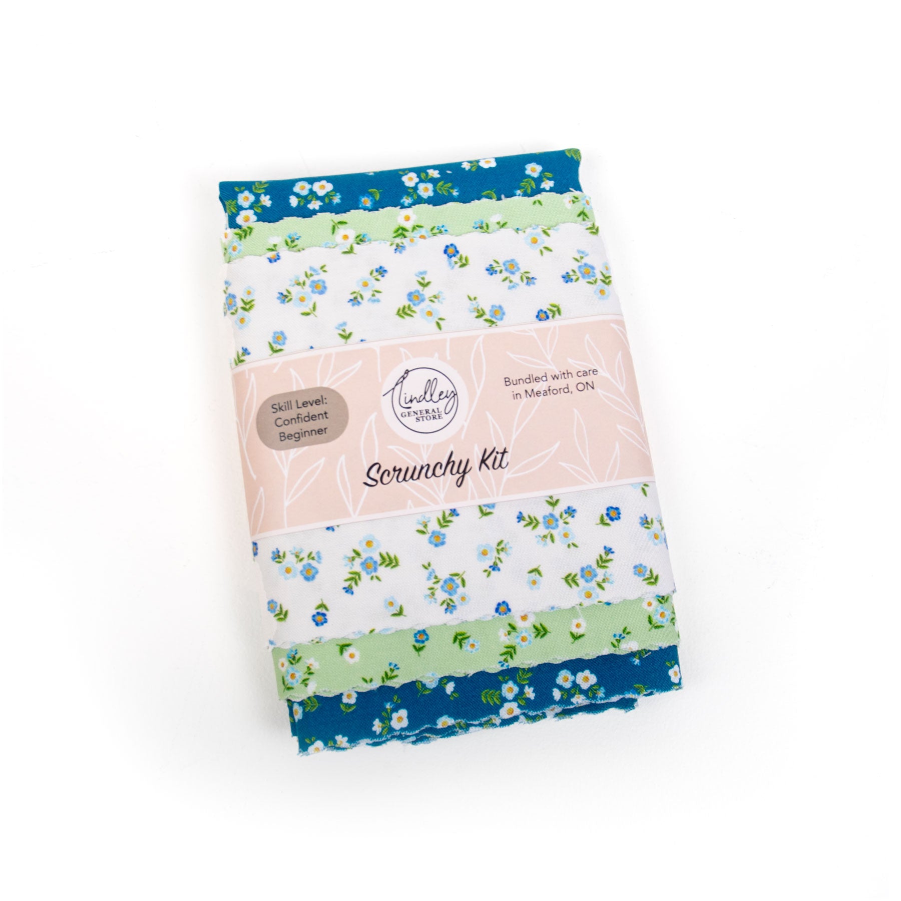 Scrunchy kit with blue, green, and white floral fabrics on a white background