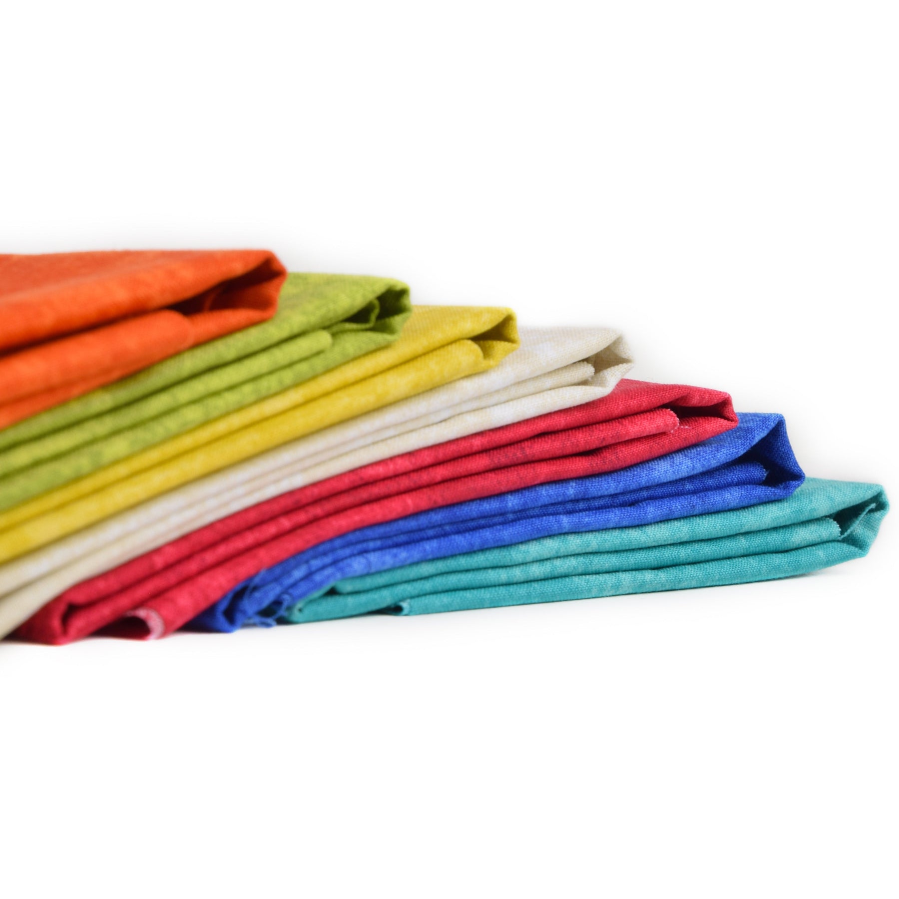 Stack of colourful folded fabrics on a white background